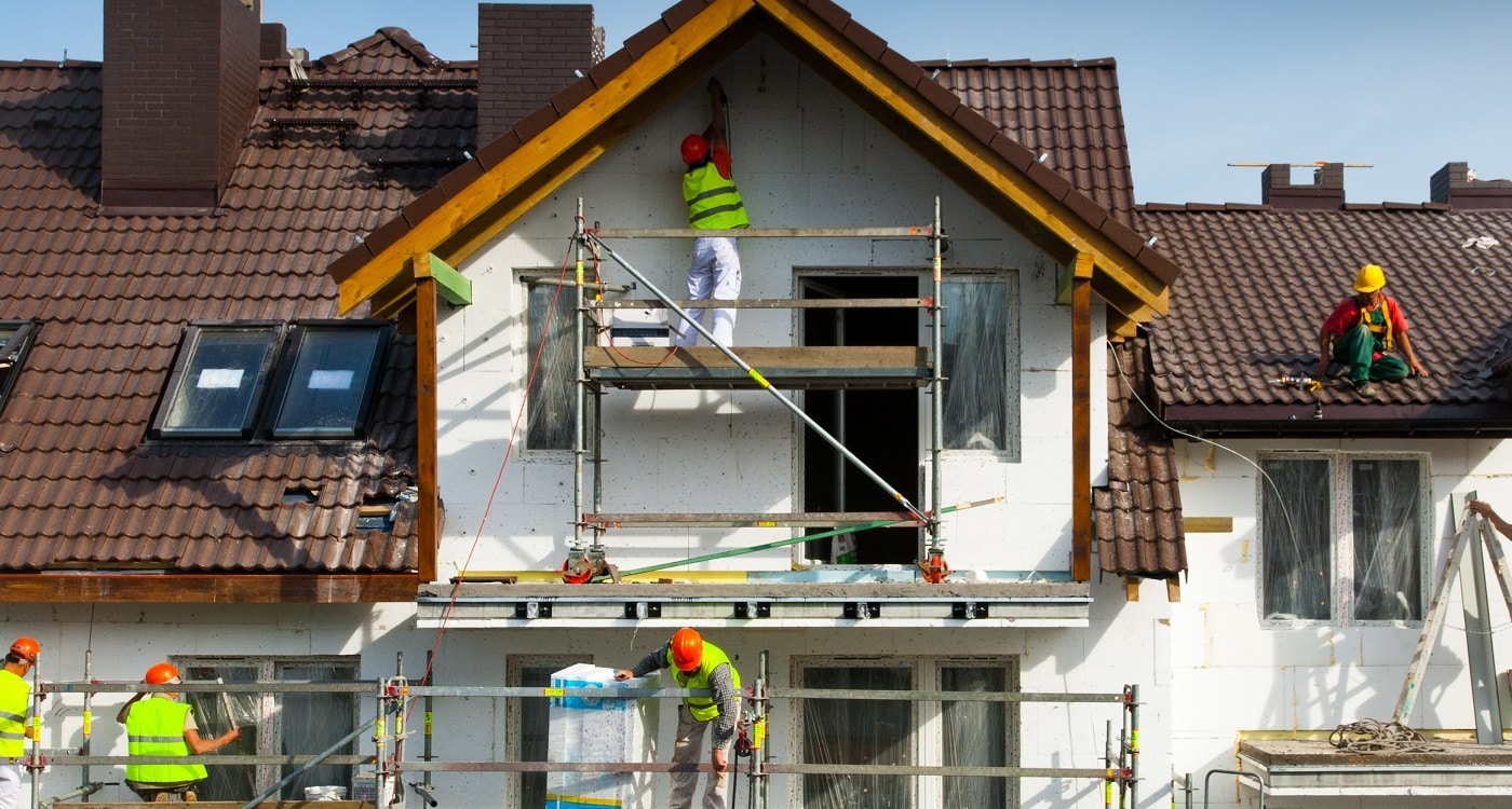 Monteure für Fassadendämmung auf einer Baustelle beantworten auch gern die faq der Kunden